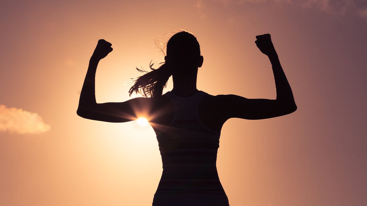 Silhouette of a strong woman confidently exhibiting her woman power.