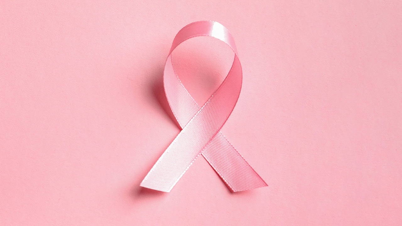 Single pink ribbon on a pink background. Image produced by More Jersey.