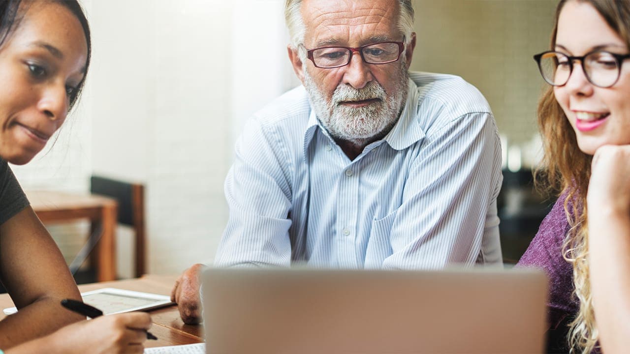 Small group of New Jersey residents working together on a laptop. Image produced by More Jersey.