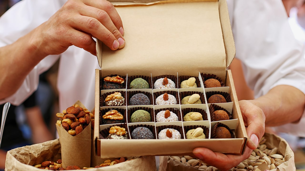 Snack company owner presenting box of handmade chocolates.