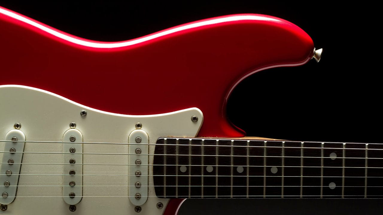Vibrant red electric guitar promoting New Jersey rock concert event.