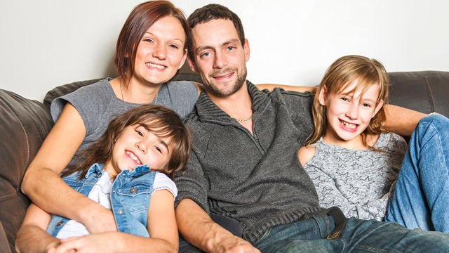 White family smiling and spending time together in their living room.