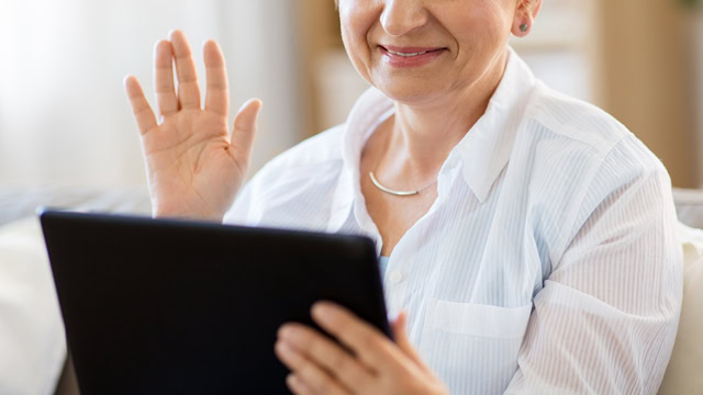 White senior woman having a video chat with her tablet at home.