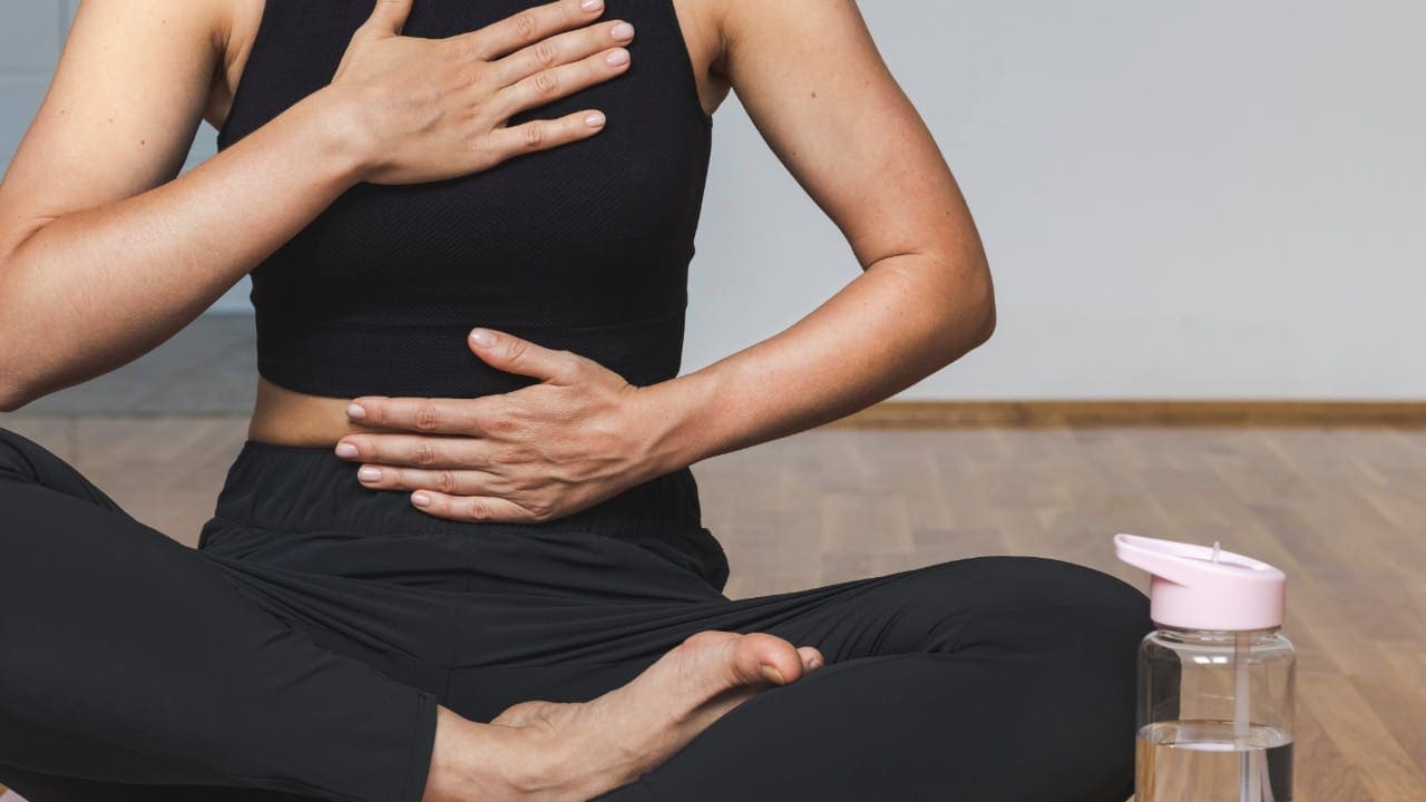 Woman doing breathing exercise sitting in lotus position.