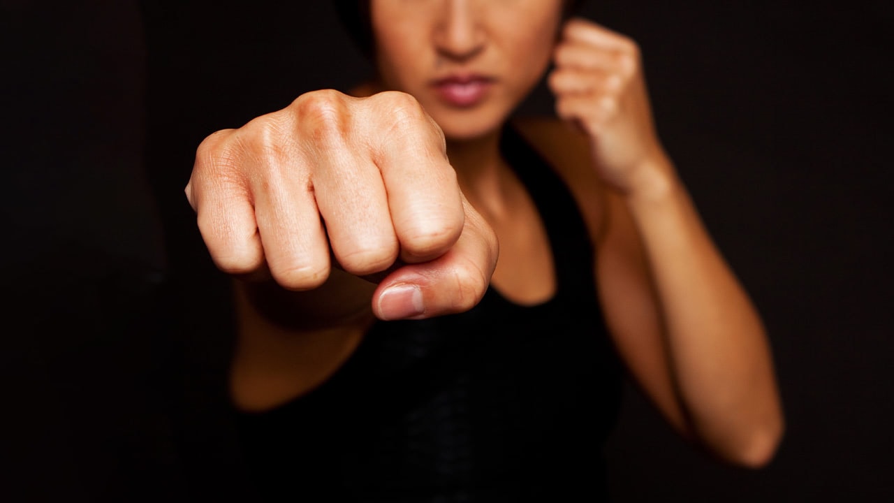 Woman making a fist at the camera for self defense course.