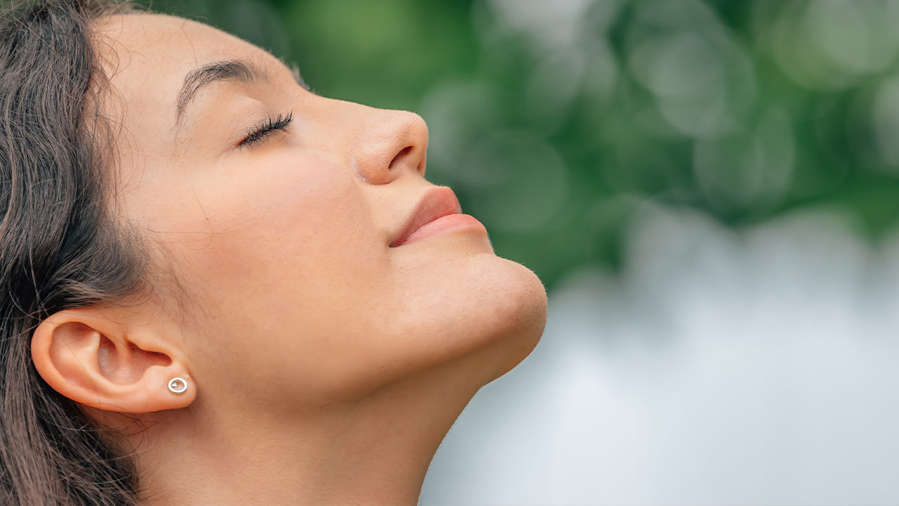 Woman performing breathing exercise routine learned at New Jersey wellness event.