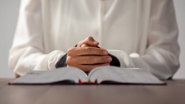 Woman sitting at desk with bible at New Jersey bible study.