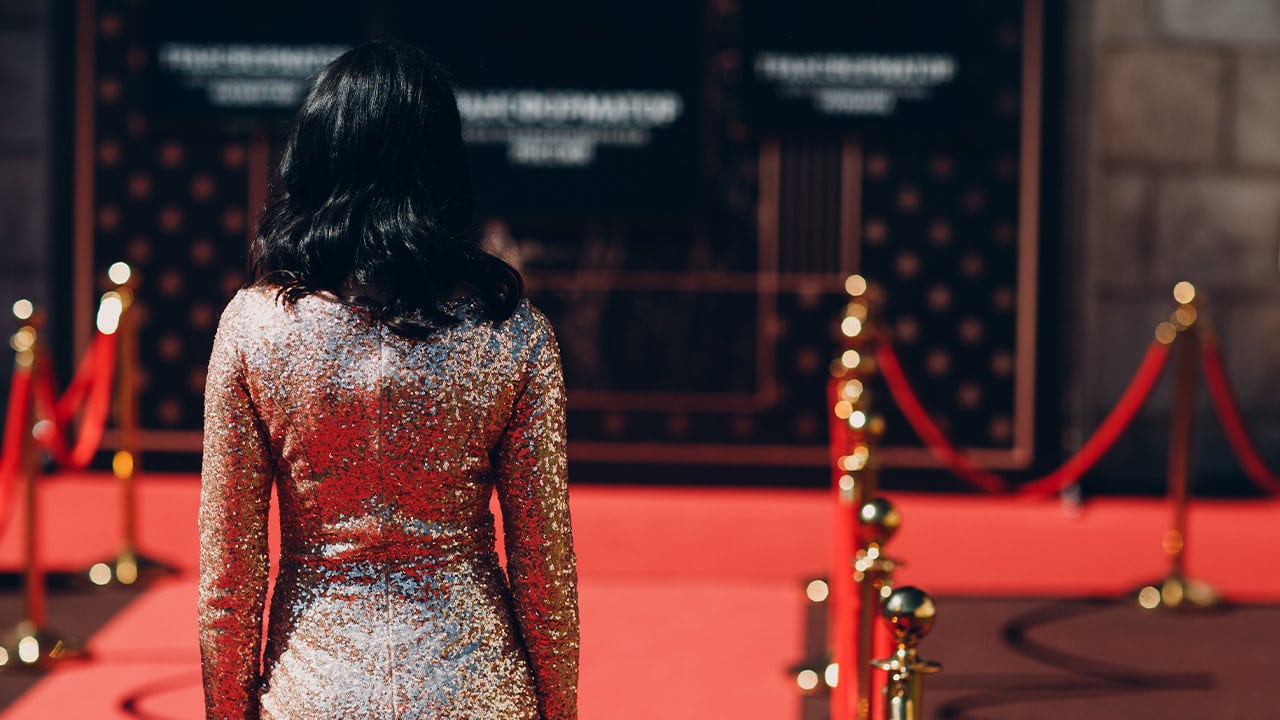 Woman wearing a sparkly dress approaching a New Jersey red carpet event.
