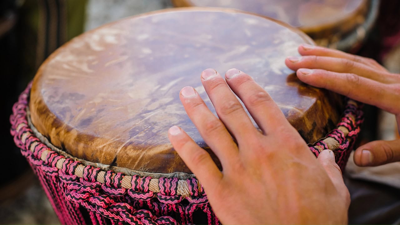 Young resident playing djembe drum at New Jersey community event. Image produced by More Jersey.