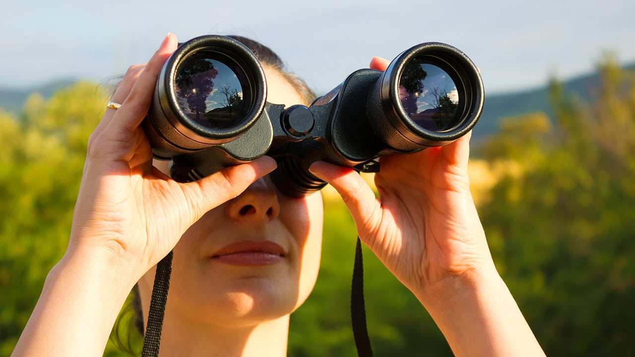 Young woman watching birds with binoculars during summer. Image produced by More Jersey.